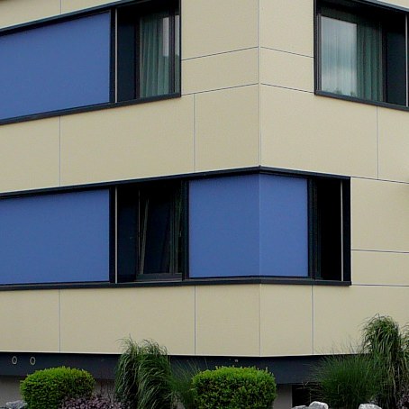 Ansicht Nordecke | Fensterbänder mit blauen Glas-Zwischenfeldern | Grossformat-Eternitplatten